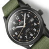 Swiss Military SM34108.07 close-up showing matte black dial, luminous hands, beige military hours, sandblast finish case, and green canvas strap.